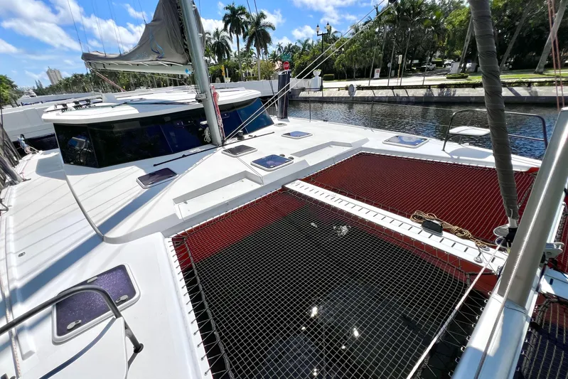 Ke'ala Yacht Photos Pics 2021 Balance 482 catamaran docked by palm trees, featuring spacious deck and netting.