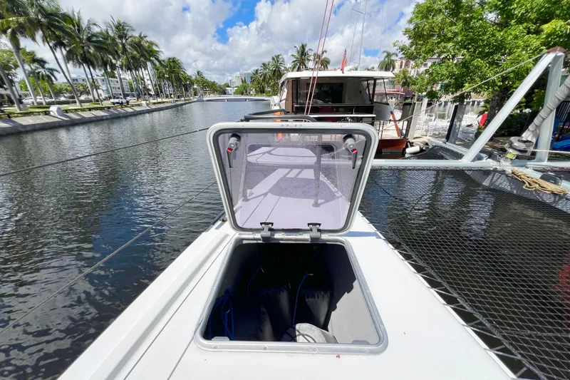 Ke'ala Yacht Photos Pics Sailboat deck with open hatch, Balance 482 model, docked by a palm-lined canal.