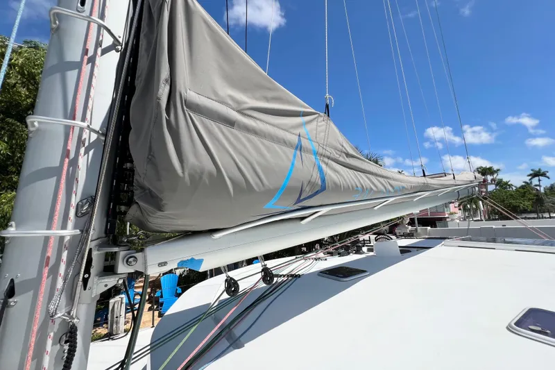 Ke'ala Yacht Photos Pics Sailboat mast and boom with sail cover, Balance 482, 2021 model, under clear blue sky.