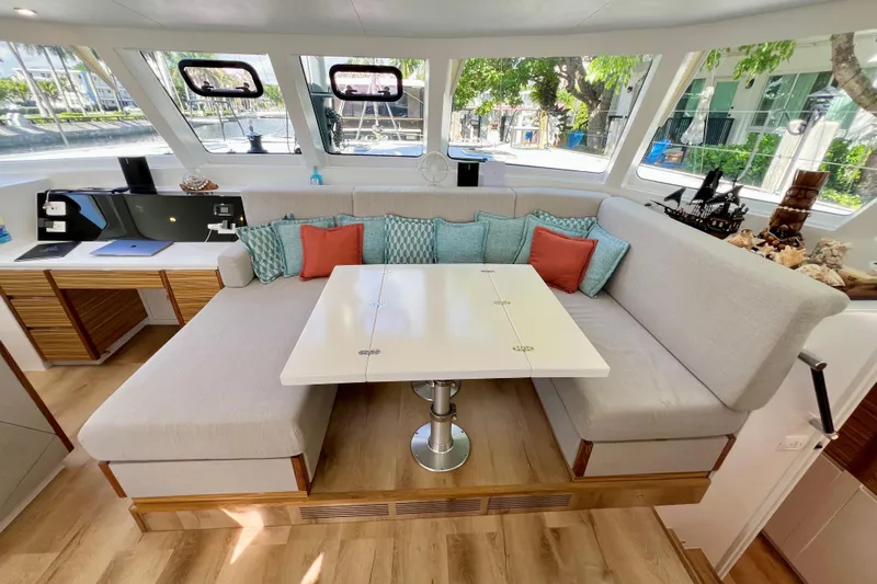 Ke'ala Yacht Photos Pics Modern yacht interior with cozy seating, decorative pillows, and a sleek table, Balance 482 model, 2021.