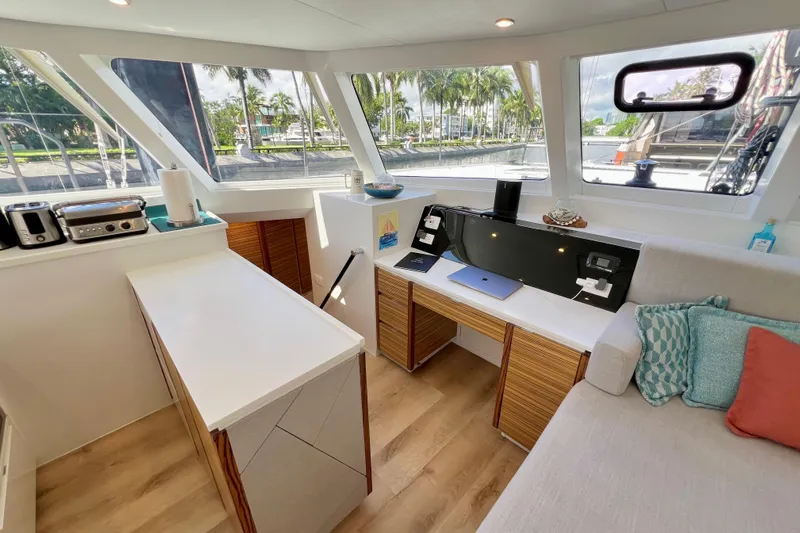 Ke'ala Yacht Photos Pics Modern yacht interior with sleek design, featuring a workspace and kitchen area, Balance 482 model.