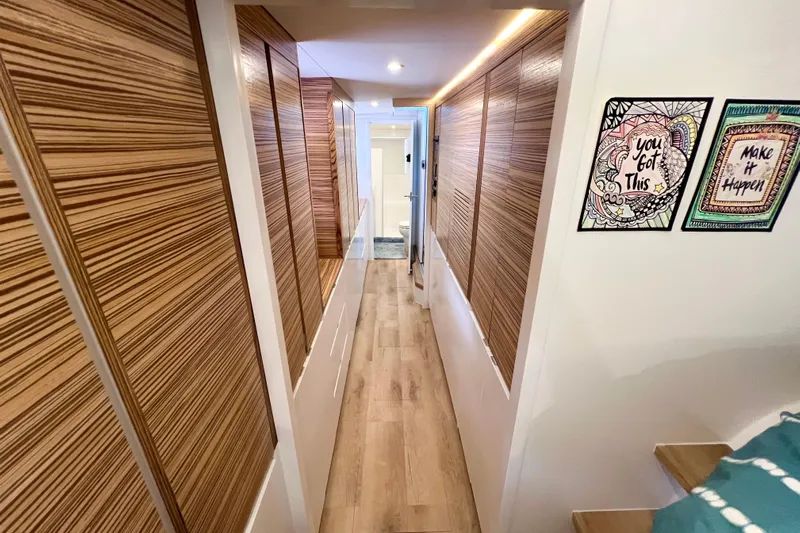 Ke'ala Yacht Photos Pics Narrow hallway in 2021 Balance 482 with wood paneling and motivational wall art.