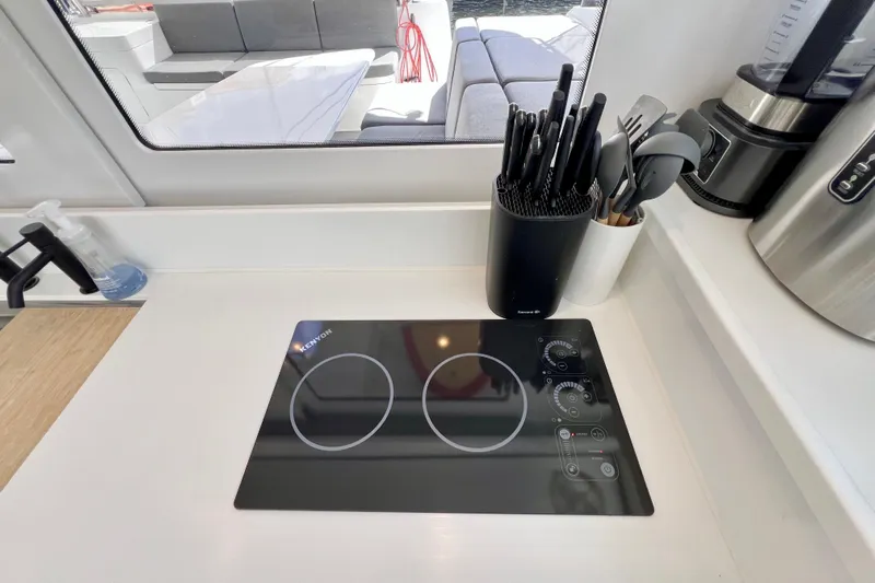 Ke'ala Yacht Photos Pics Modern kitchen with induction cooktop, knife set, and utensils on a Balance 482 yacht, 2021 model.