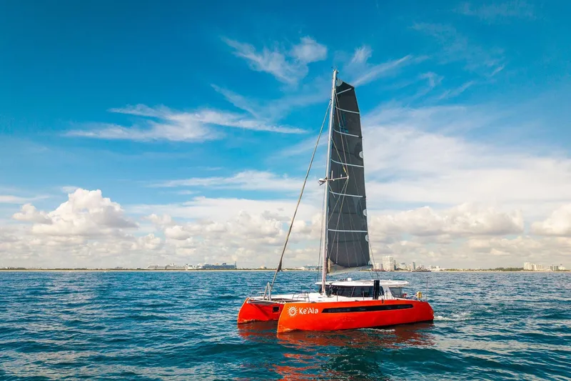 Ke'ala Yacht Photos Pics Red Balance 482 catamaran sailing on blue ocean under clear sky, 2021 model.