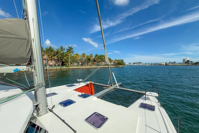 Ke'ala Yacht Photos Pics Sailing catamaran Balance 482 on tropical waters near palm-lined shore, 2021 model.