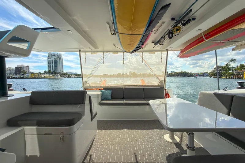 Ke'ala Yacht Photos Pics Luxurious 2021 Balance 482 yacht interior with waterfront view, featuring seating and surfboards.