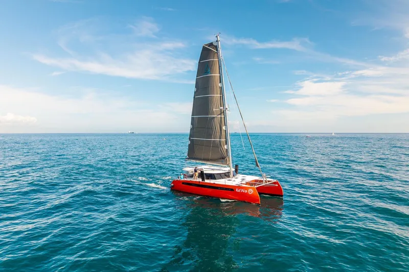 Ke'ala Yacht Photos Pics Red Balance 482 catamaran sailing on open sea under clear blue sky, 2021 model.