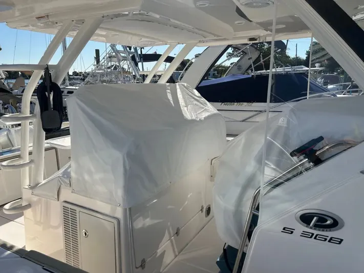 "ahhh Nice" Yacht Photos Pics 2018 Pursuit S 368 Sport boat docked, partially covered.