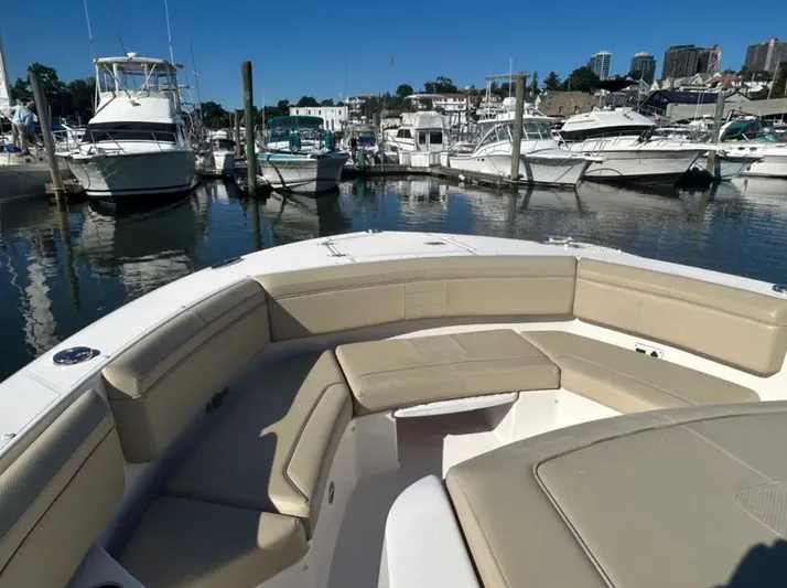 "ahhh Nice" Yacht Photos Pics 2018 Pursuit S 368 Sport in marina, featuring beige seating area.