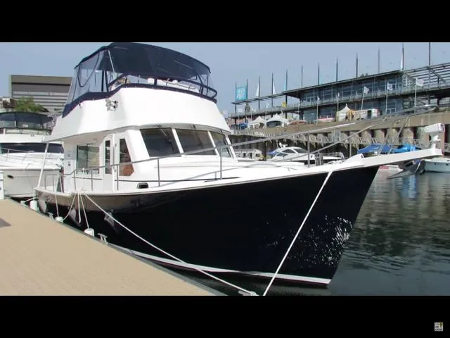 Mano 1 Yacht Photos Pics 2011 Mainship 395 Trawler docked at marina, featuring sleek design and spacious upper deck.