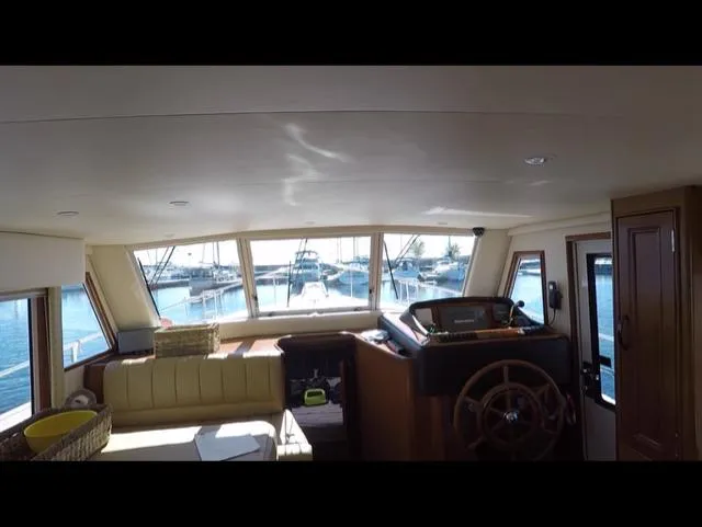 Mano 1 Yacht Photos Pics Interior view of 2011 Mainship 395 Trawler with helm and marina backdrop.