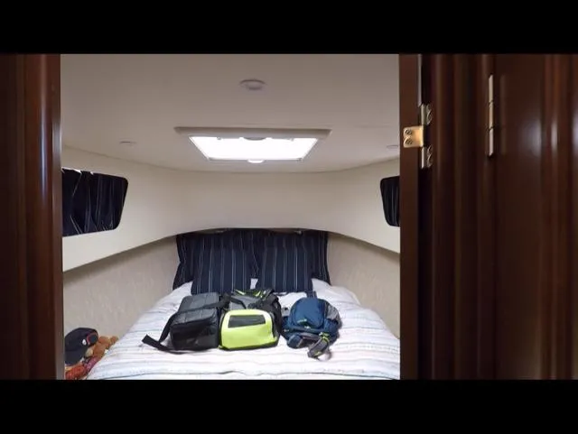 Mano 1 Yacht Photos Pics Cozy cabin interior of 2011 Mainship 395 Trawler with bags on bed.