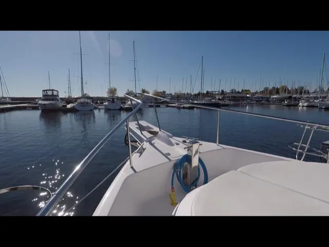 Mano 1 Yacht Photos Pics 2011 Mainship 395 Trawler docked in a marina with sailboats under clear blue sky.