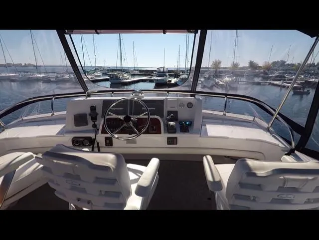 Mano 1 Yacht Photos Pics 2011 Mainship 395 Trawler helm with marina view, featuring dual seats and navigation controls.