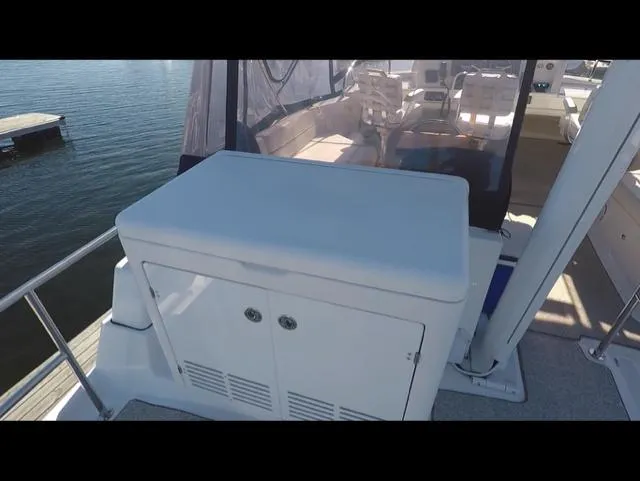 Mano 1 Yacht Photos Pics 2011 Mainship 395 Trawler deck with storage cabinet, overlooking calm waters.