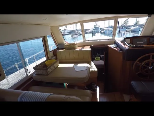 Mano 1 Yacht Photos Pics Interior of 2011 Mainship 395 Trawler with seating and helm, overlooking marina.