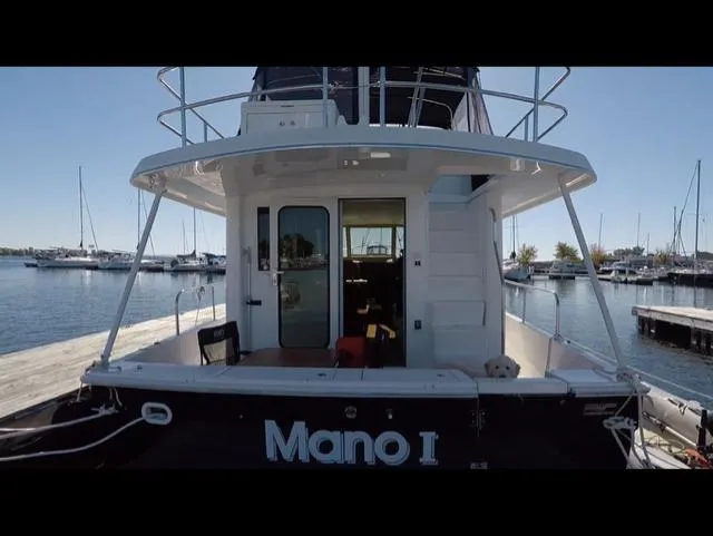 Mano 1 Yacht Photos Pics 2011 Mainship 395 Trawler docked at marina, rear view with open deck.