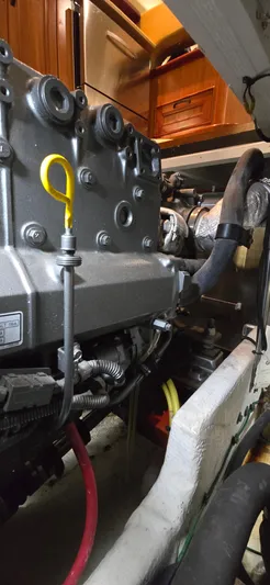 Mano 1 Yacht Photos Pics Engine room of 2011 Mainship 395 Trawler, showcasing mechanical components and yellow dipstick.