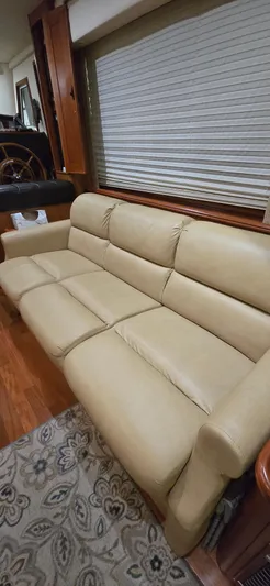 Mano 1 Yacht Photos Pics Beige leather sofa in 2011 Mainship 395 Trawler interior, with wooden accents and patterned rug.