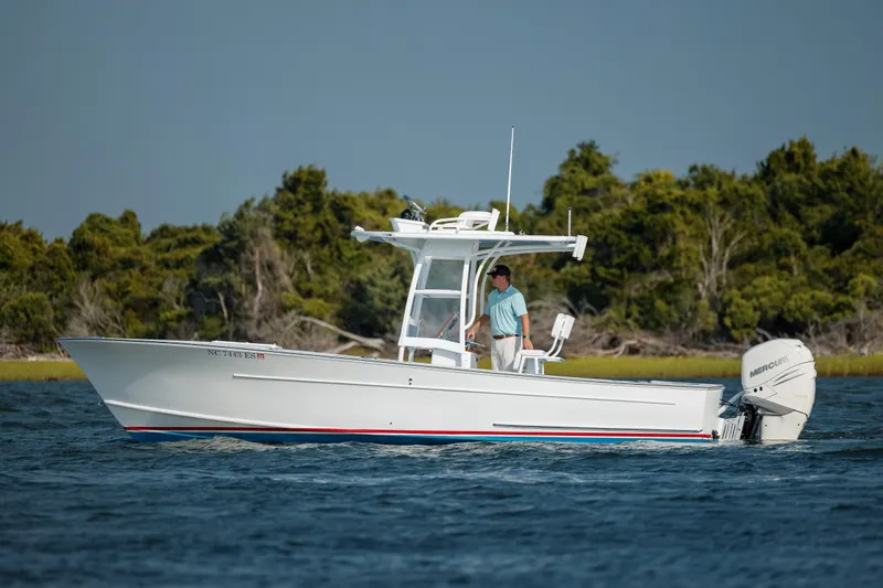  Yacht Photos Pics 2019 Gamefisherman 26 Cuddy Cabin boat on water, with trees in background.