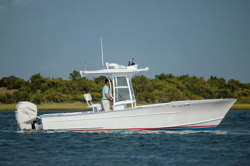  Yacht Photos Pics 2019 Gamefisherman 26 Cuddy Cabin boat cruising on water with scenic background.