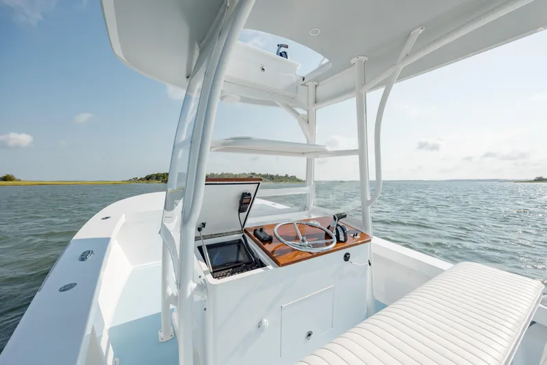  Yacht Photos Pics 2019 Gamefisherman 26 Cuddy Cabin boat interior with steering wheel, on open water.