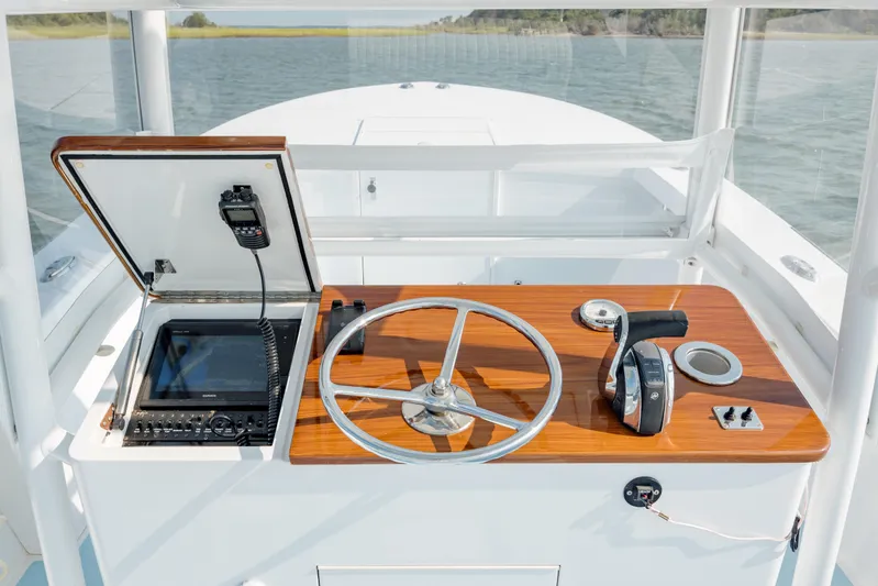  Yacht Photos Pics 2019 Gamefisherman 26 Cuddy Cabin helm with steering wheel and navigation equipment.