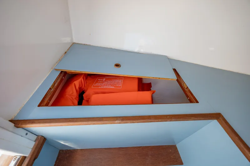  Yacht Photos Pics 2019 Gamefisherman 26 Cuddy Cabin storage with orange life jackets.