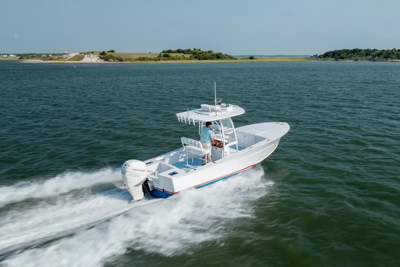  Yacht Photos Pics 2019 Gamefisherman 26 Cuddy Cabin cruising on open water, showcasing sleek design and performance.