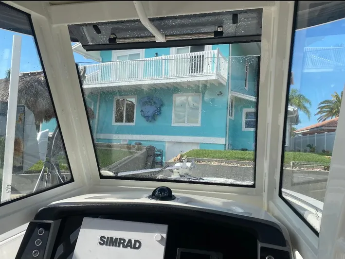  Yacht Photos Pics View from 2021 Robalo R272 Center Console boat, featuring Simrad navigation, facing a turquoise house.