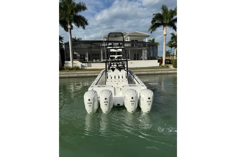  Yacht Photos Pics 2020 SeaHunter 41 CTS boat with four powerful outboard engines docked near a waterfront home.