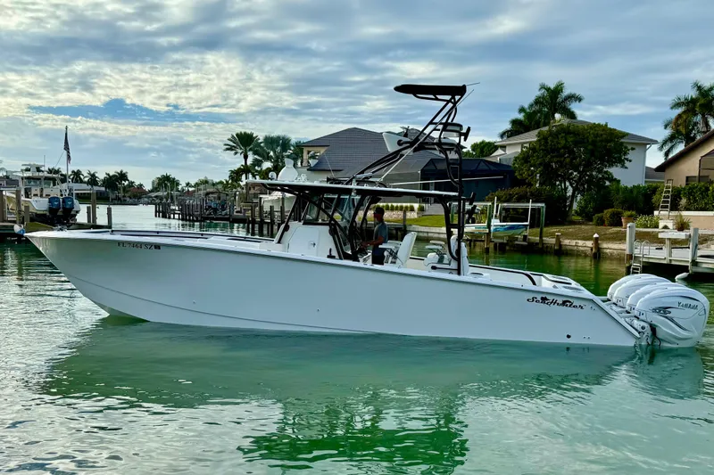  Yacht Photos Pics 2020 SeaHunter 41 CTS boat on calm water, surrounded by docks and palm trees.