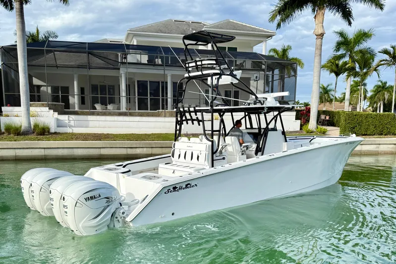  Yacht Photos Pics 2020 SeaHunter 41 CTS boat with triple Yamaha engines docked near a luxury waterfront home.