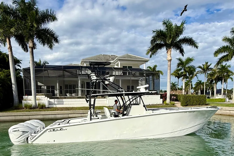  Yacht Photos Pics 2020 SeaHunter 41 CTS boat cruising near a waterfront home with palm trees.