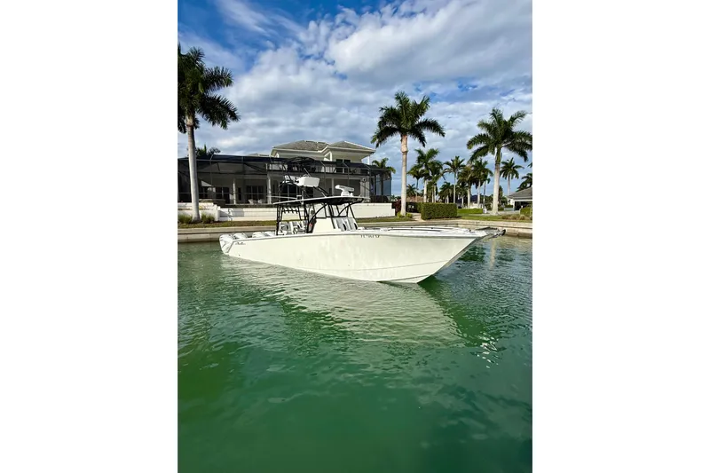  Yacht Photos Pics 2020 SeaHunter 41 CTS boat docked near palm trees and a modern house.