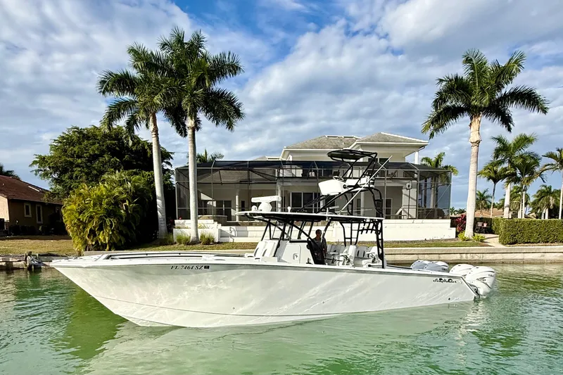  Yacht Photos Pics 2020 SeaHunter 41 CTS boat on water, with palm trees and a house in the background.