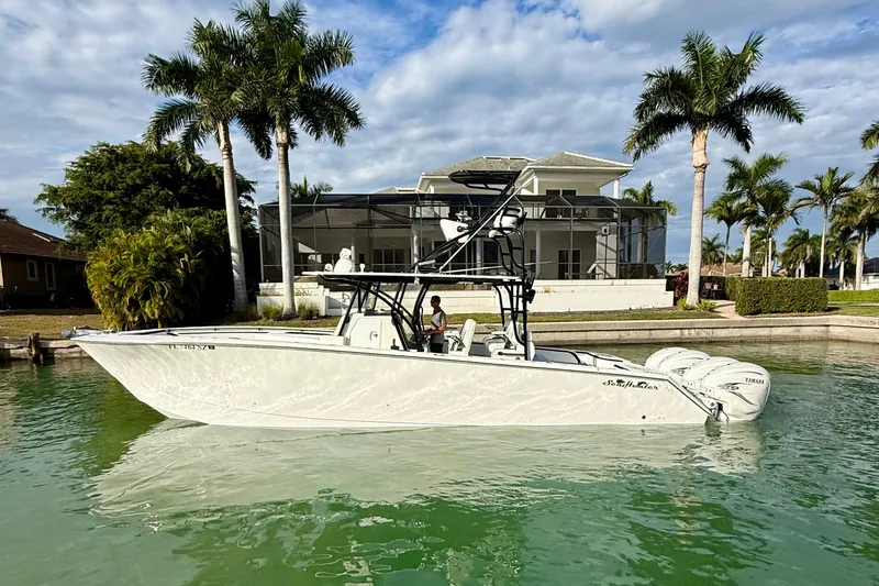  Yacht Photos Pics 2020 SeaHunter 41 CTS boat on water, near a waterfront home with palm trees.