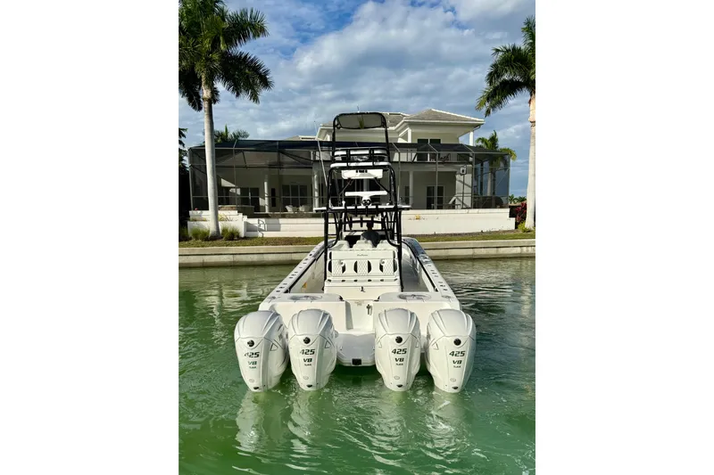  Yacht Photos Pics 2020 SeaHunter 41 CTS boat with four powerful outboard engines docked near a modern house.