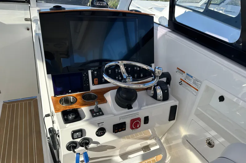  Yacht Photos Pics 2020 Southport 33DC boat helm with steering wheel, controls, and navigation display.