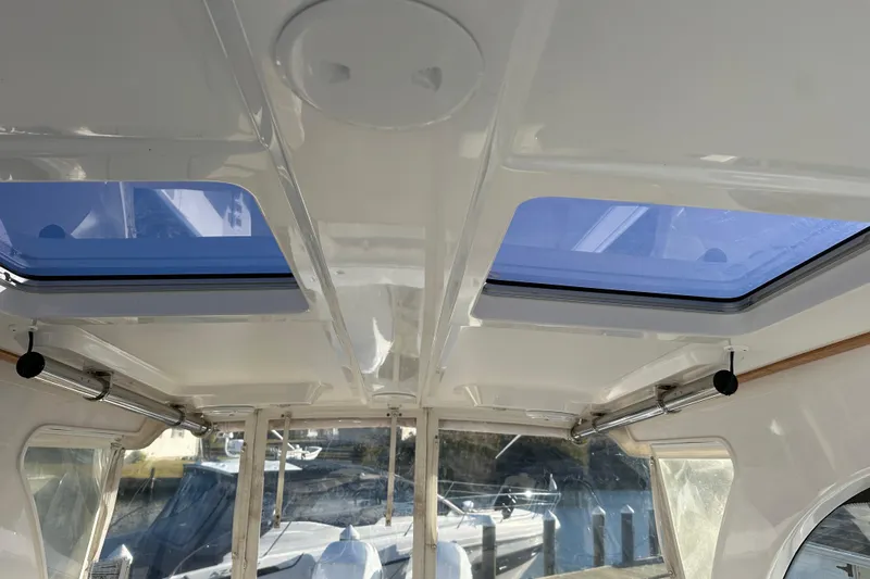  Yacht Photos Pics Interior view of 2020 Southport 33DC boat with skylights and docked boats visible.