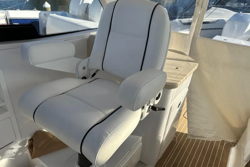  Yacht Photos Pics Captain's chair on 2020 Southport 33DC boat, featuring white upholstery and armrests.