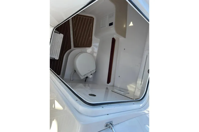  Yacht Photos Pics 2020 Southport 33DC boat interior with compact toilet and wooden flooring.