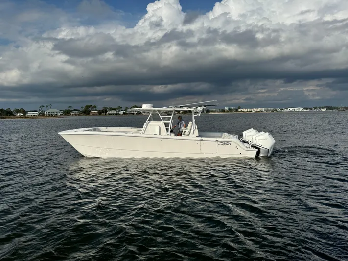  Yacht Photos Pics 2022 Invincible 35 Catamaran on calm waters under cloudy skies.
