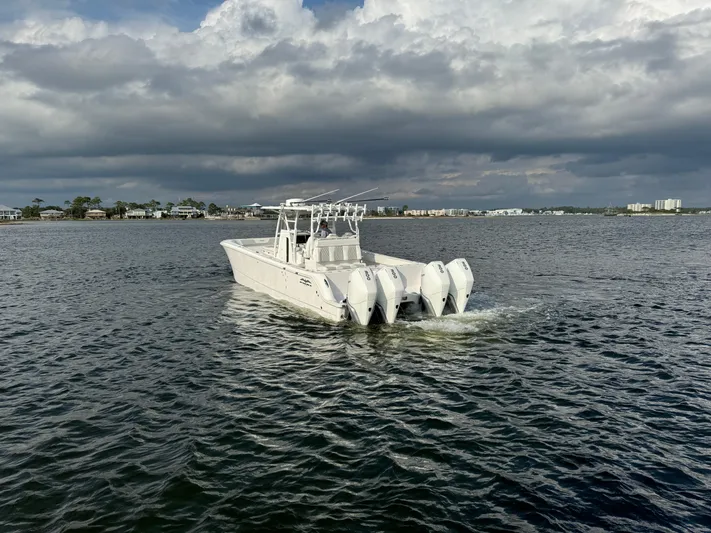  Yacht Photos Pics 2022 Invincible 35 Catamaran cruising on open water under cloudy skies.