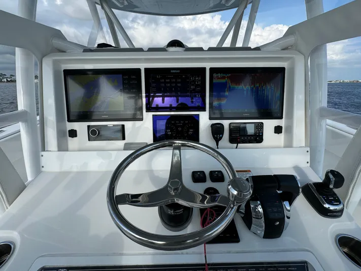  Yacht Photos Pics Invincible 35 Catamaran 2022 dashboard with steering wheel and navigation screens.
