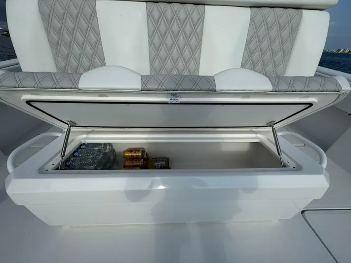  Yacht Photos Pics Invincible 35 Catamaran 2022 with open storage compartment, containing drinks and water bottles.