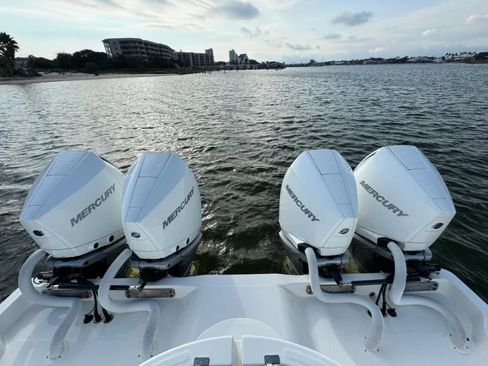  Yacht Photos Pics 2022 Invincible 35 Catamaran with four Mercury outboard engines on a calm waterway.