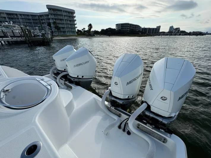  Yacht Photos Pics 2022 Invincible 35 Catamaran with Mercury outboard engines on a calm waterfront.