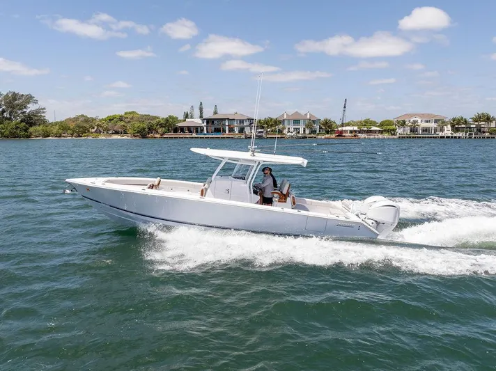  Yacht Photos Pics 2022 Jupiter 32 boat cruising on a sunny day near waterfront homes.