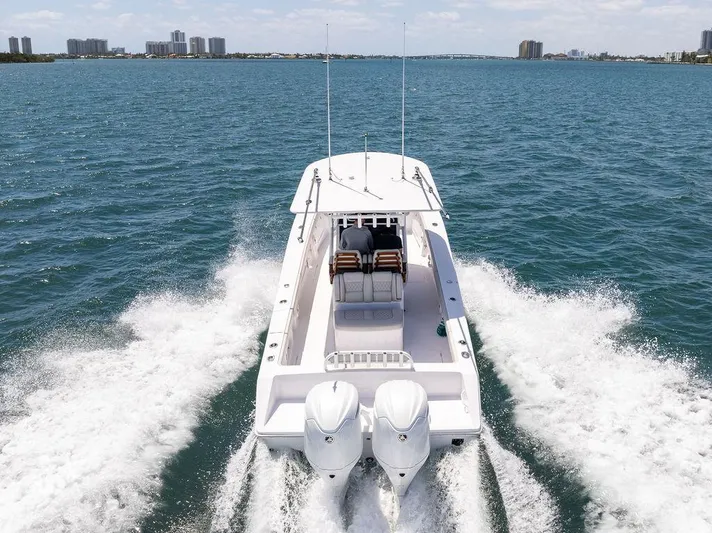  Yacht Photos Pics 2022 Jupiter 32 boat cruising on open water with city skyline in background.